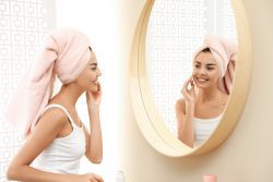 woman admiring skin in mirror