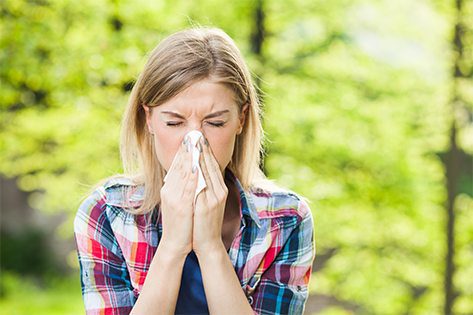 woman blowing her nose into tissue