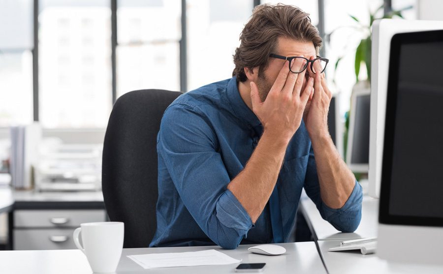 man rubbing eyes out of tiredness