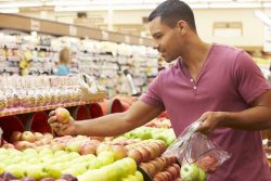 man shopping for apples in store