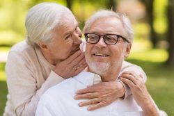 elderly woman talking to elderly man