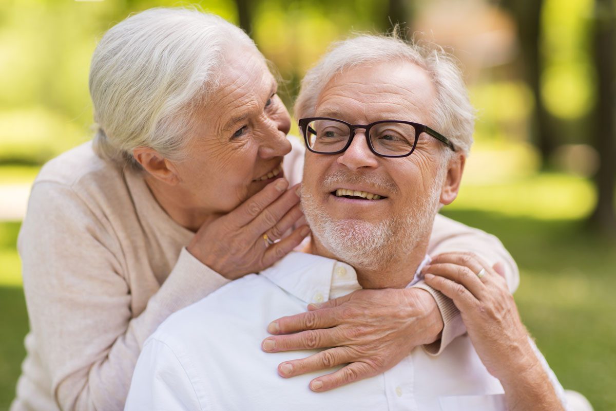 elderly woman talking to elderly man