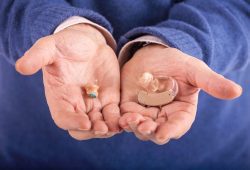 man holding hearing aids