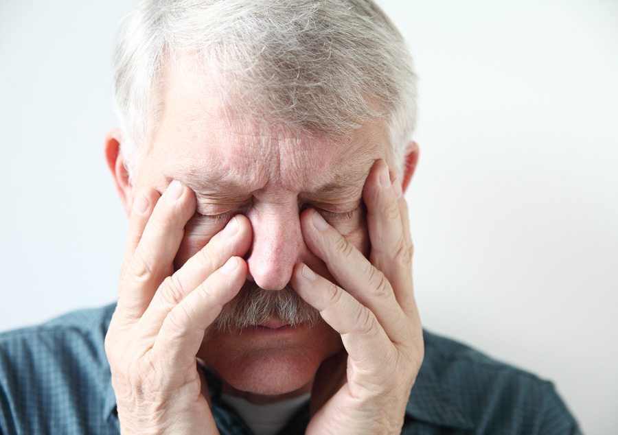 man holding sinuses in pain